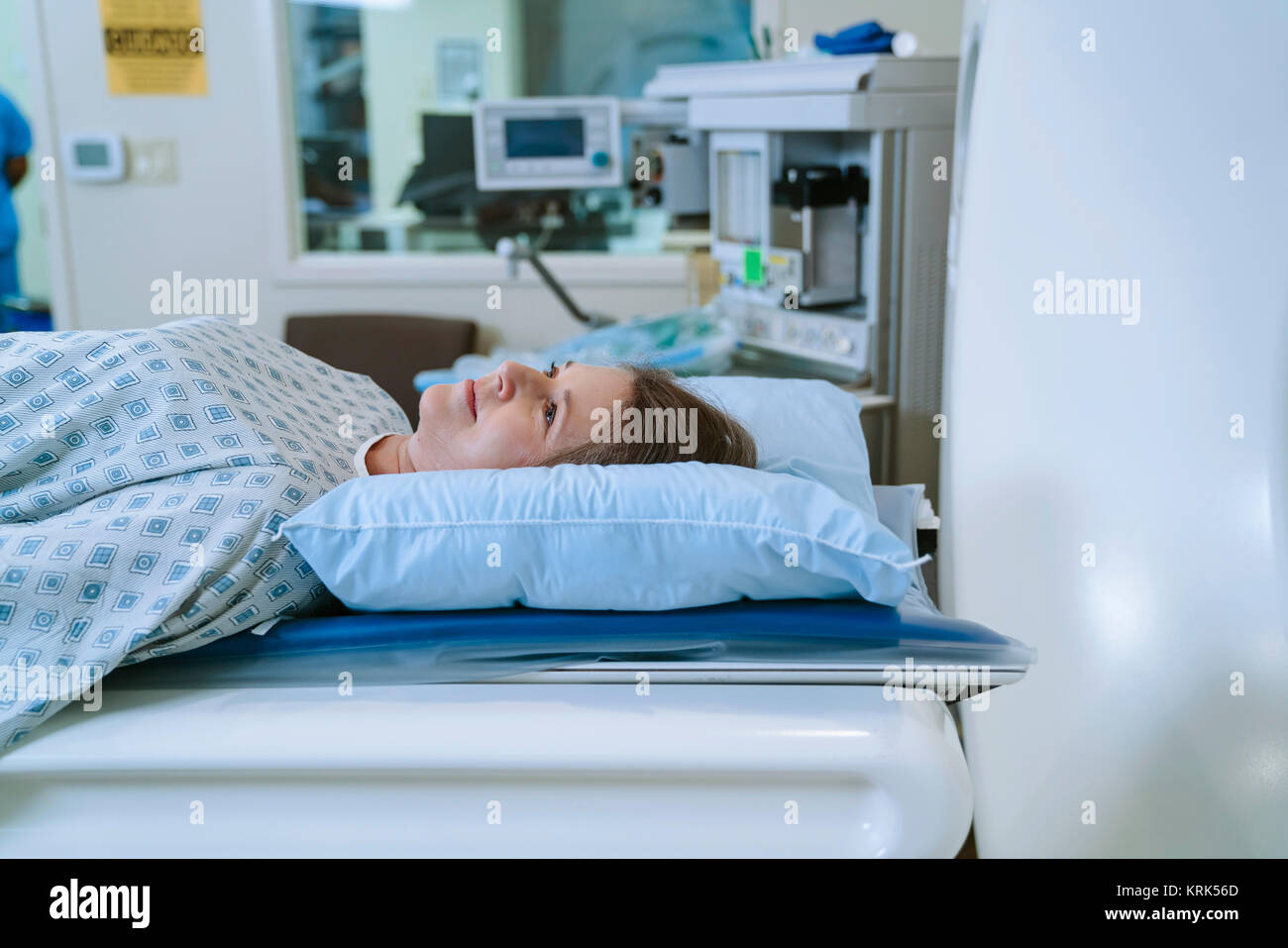 Caucasian woman laying on scanner table Stock Photo
