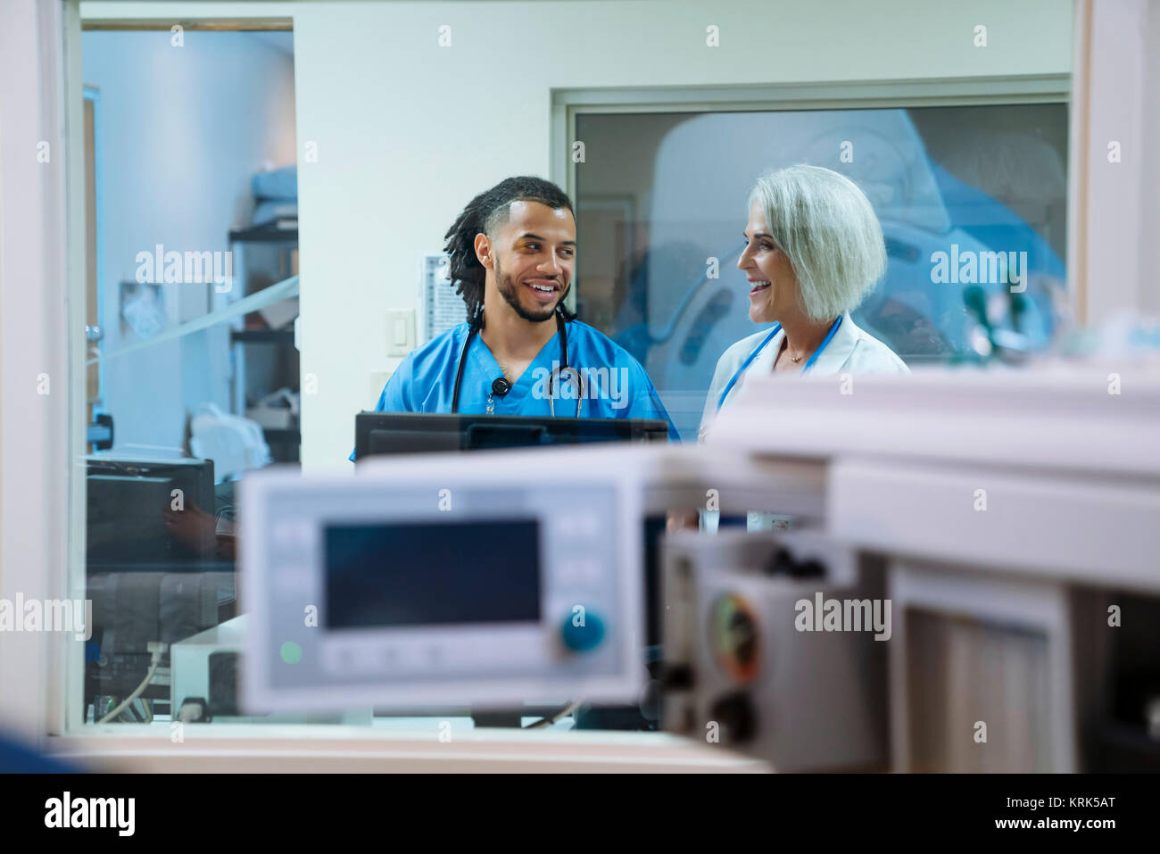 Smiling doctor and nurse talking Stock Photo - Alamy
