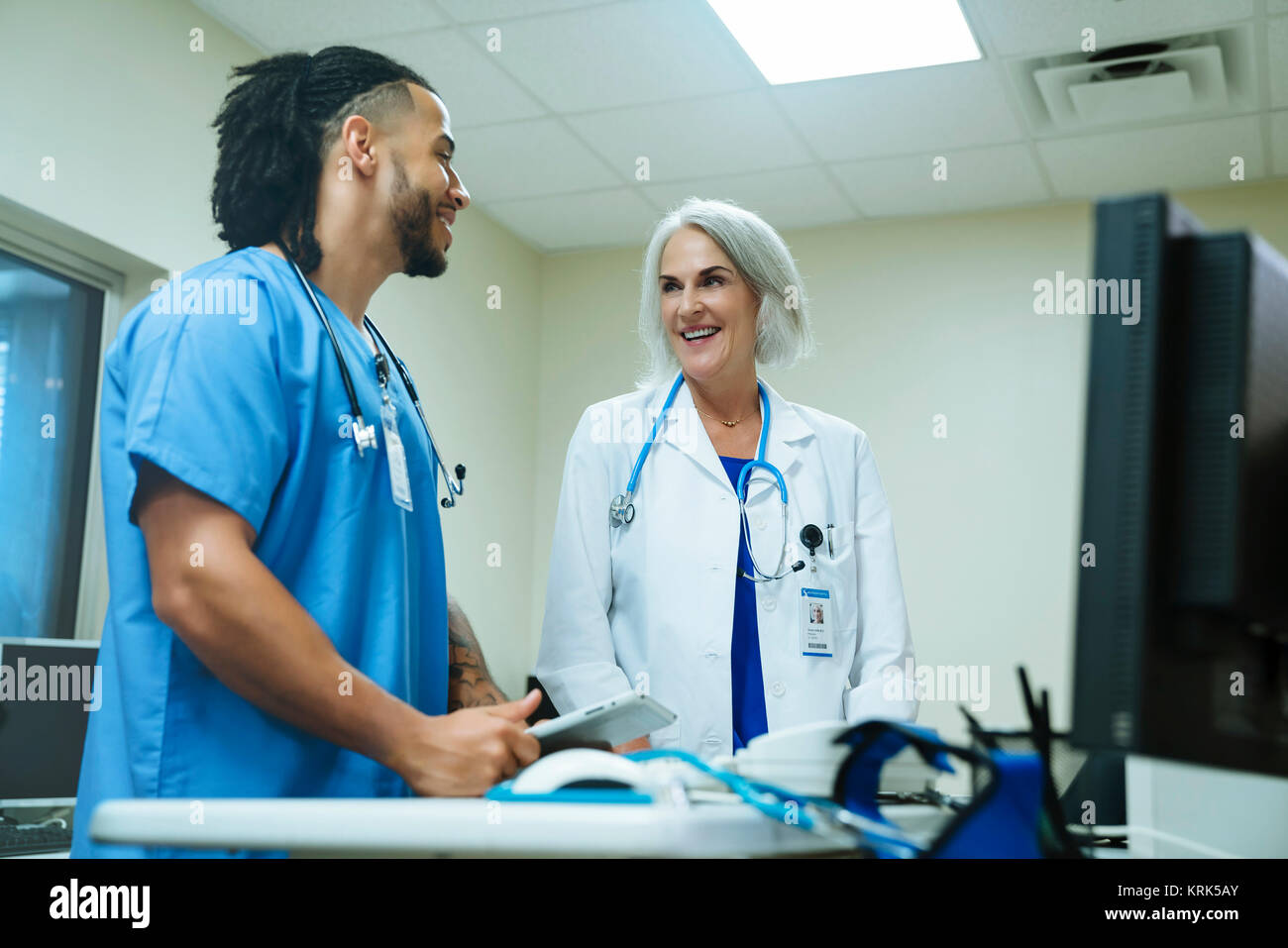 Smiling doctor and nurse talking Stock Photo - Alamy