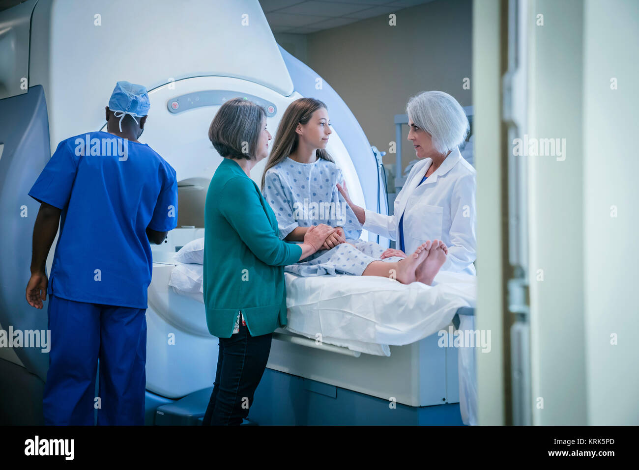 Doctor comforting patient at scanner Stock Photo
