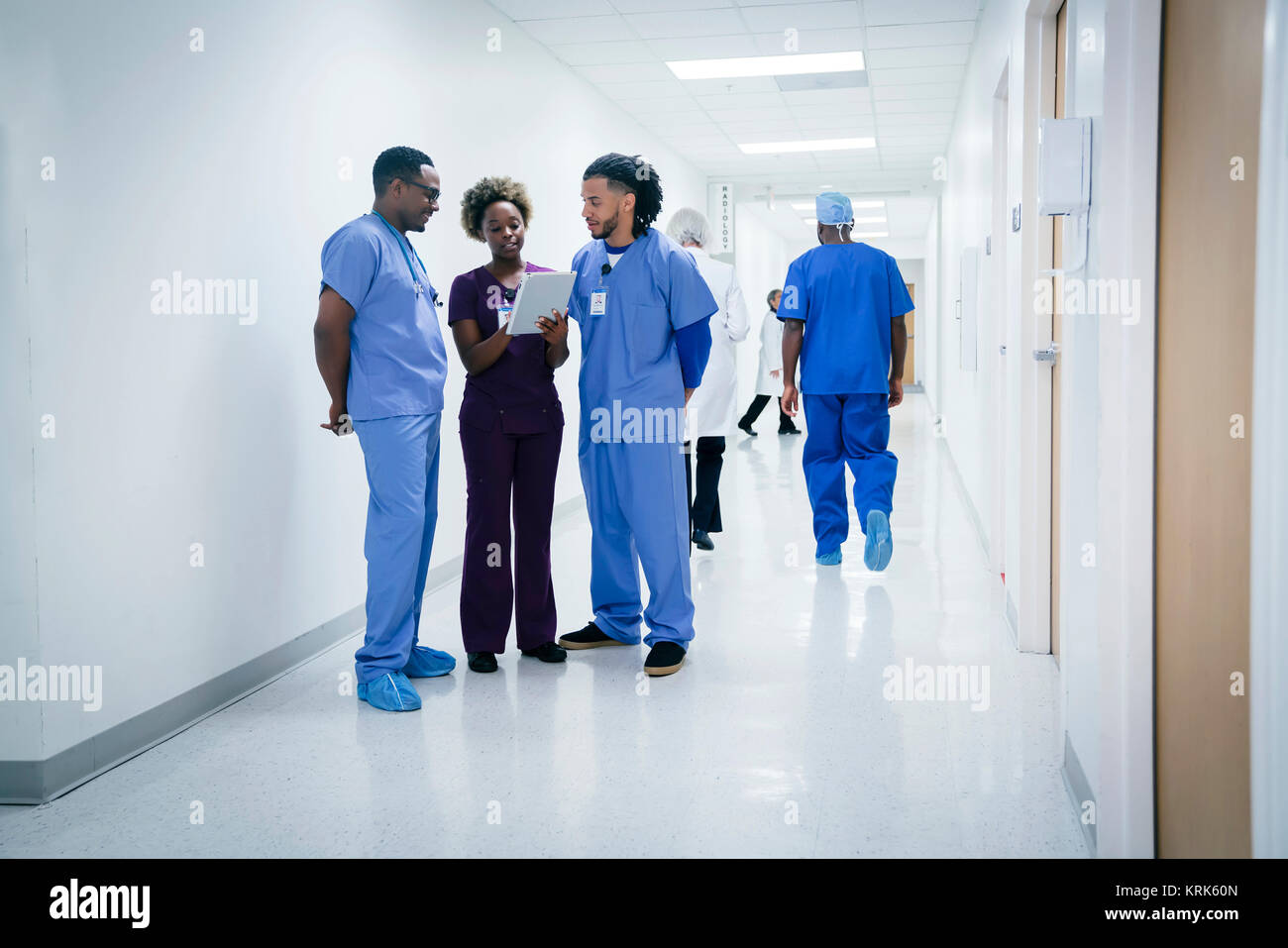 Nurses discussing digital tablet in hospital Stock Photo