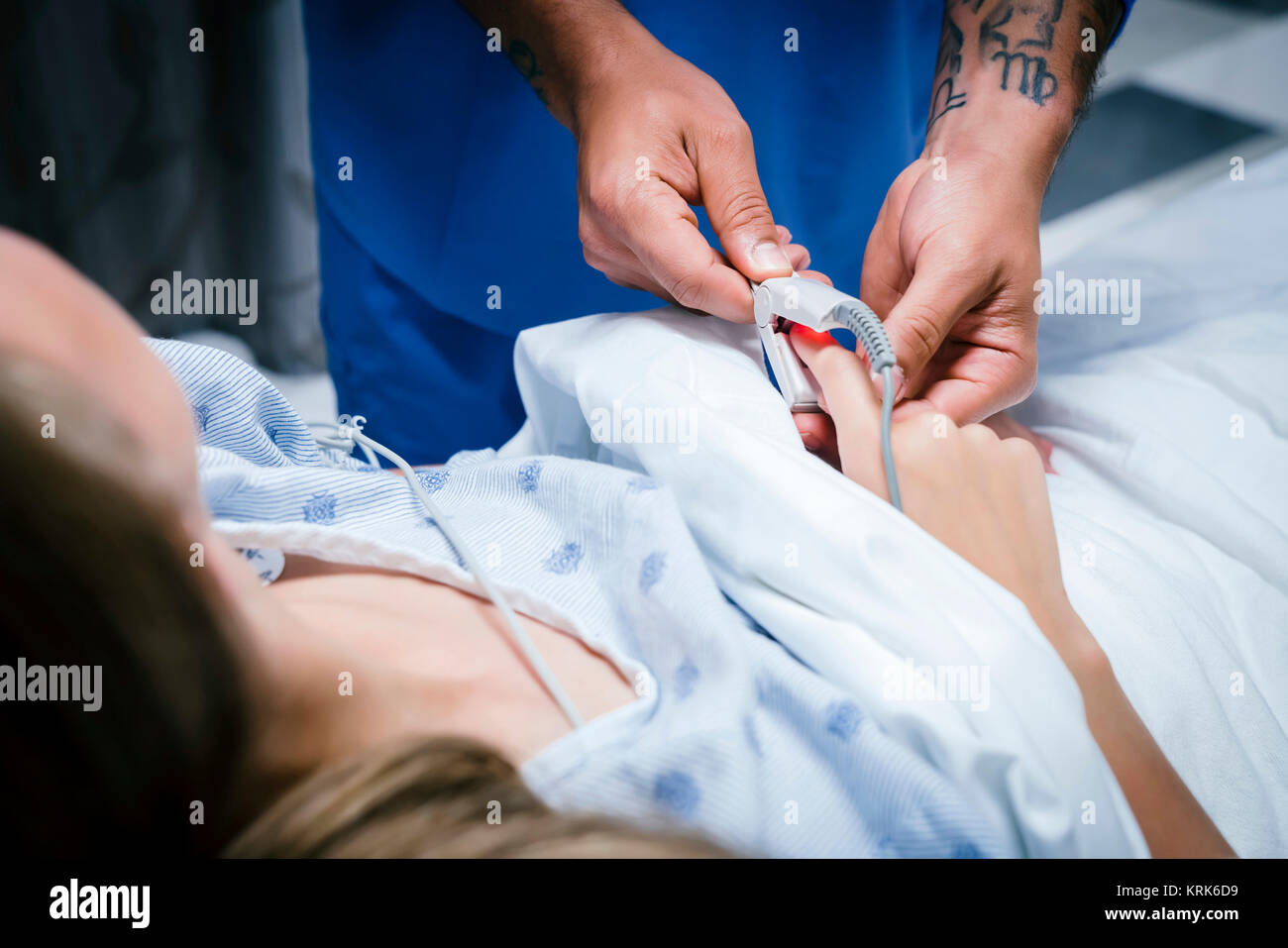 Nurse placing finger monitor on patient Stock Photo