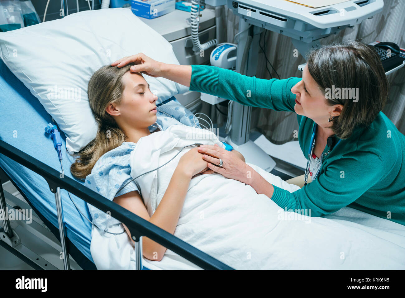 Caucasian doctor comforting patient in hospital bed Stock Photo