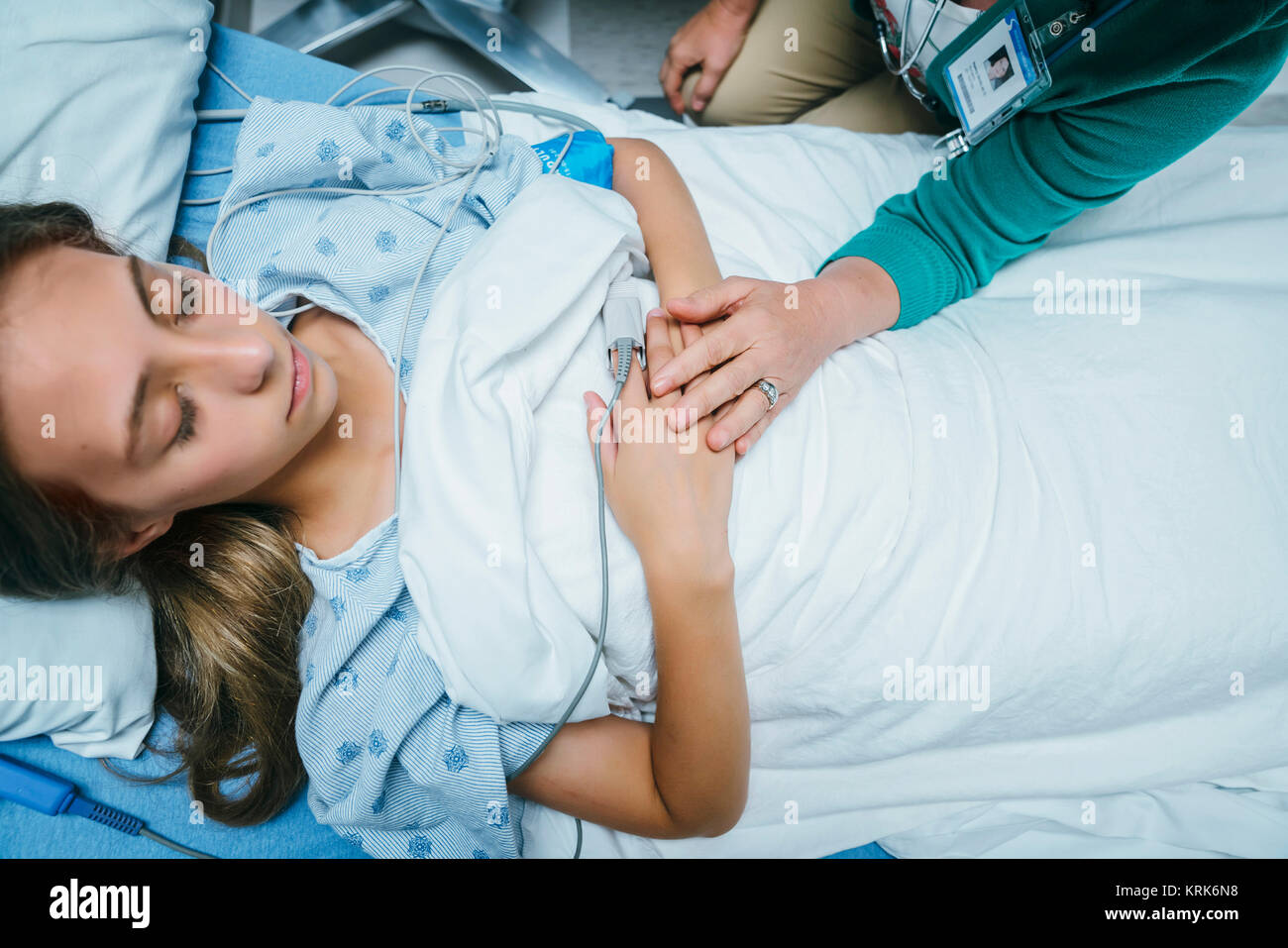 Caucasian doctor comforting patient in hospital bed Stock Photo