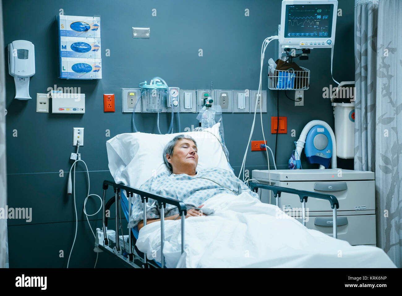 Mixed race patient sleeping in hospital bed Stock Photo