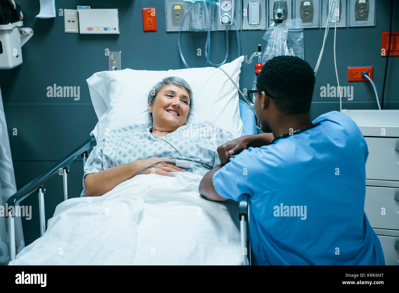 Nurse talking to patient in hospital bed Stock Photo