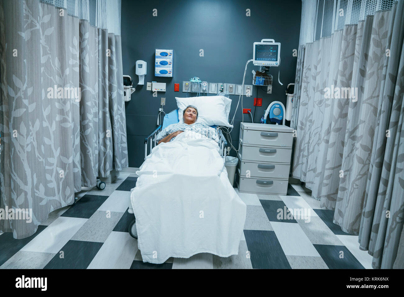 Mixed race patient sleeping in hospital bed Stock Photo
