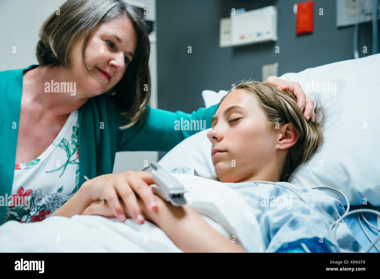 Caucasian mother comforting daughter in hospital Stock Photo