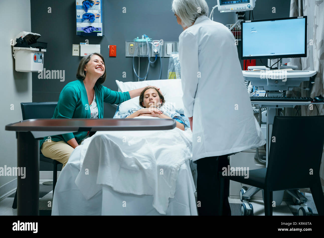Caucasian doctor talking to mother and daughter in hospital Stock Photo
