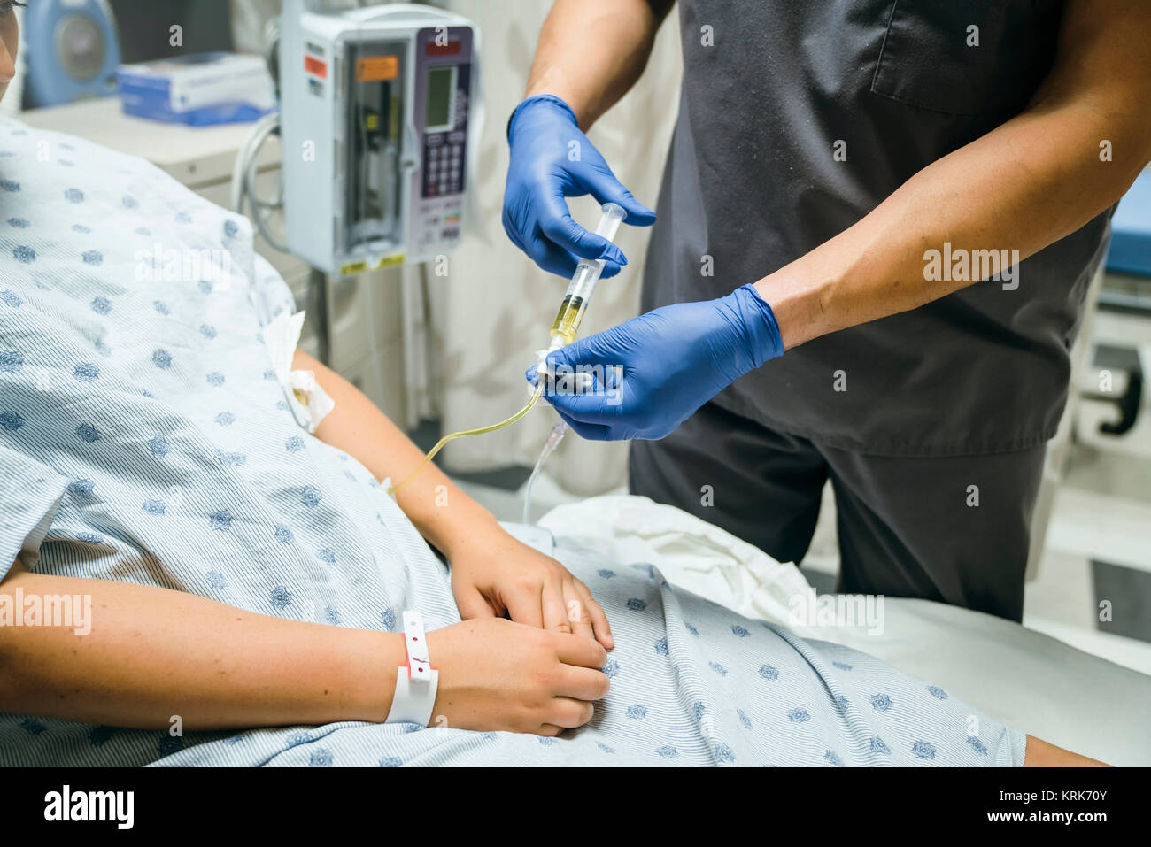 Nurse injecting medicine into tube of patient Stock Photo