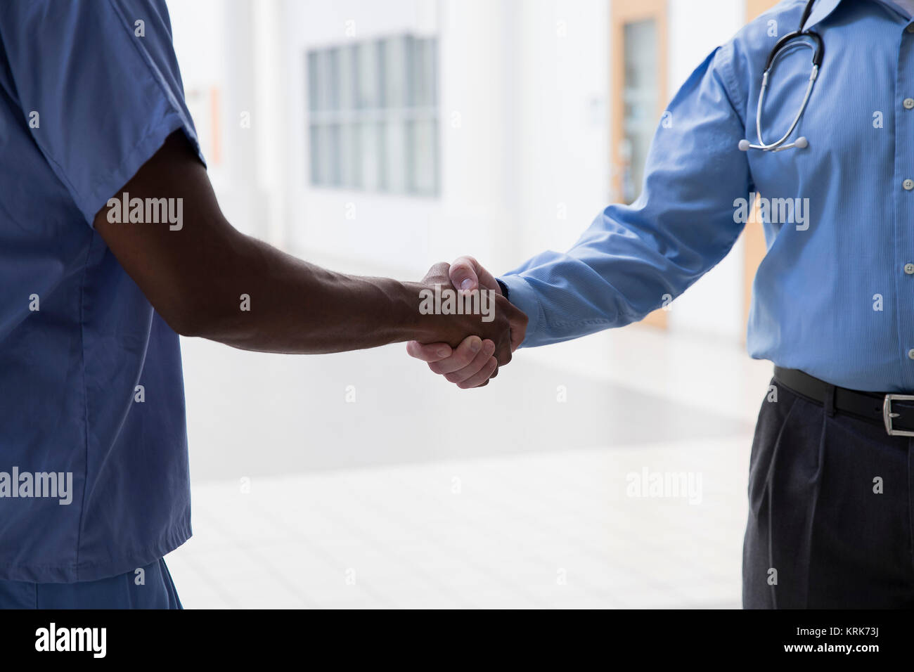 Close up of doctor and nurse shaking hands Stock Photo