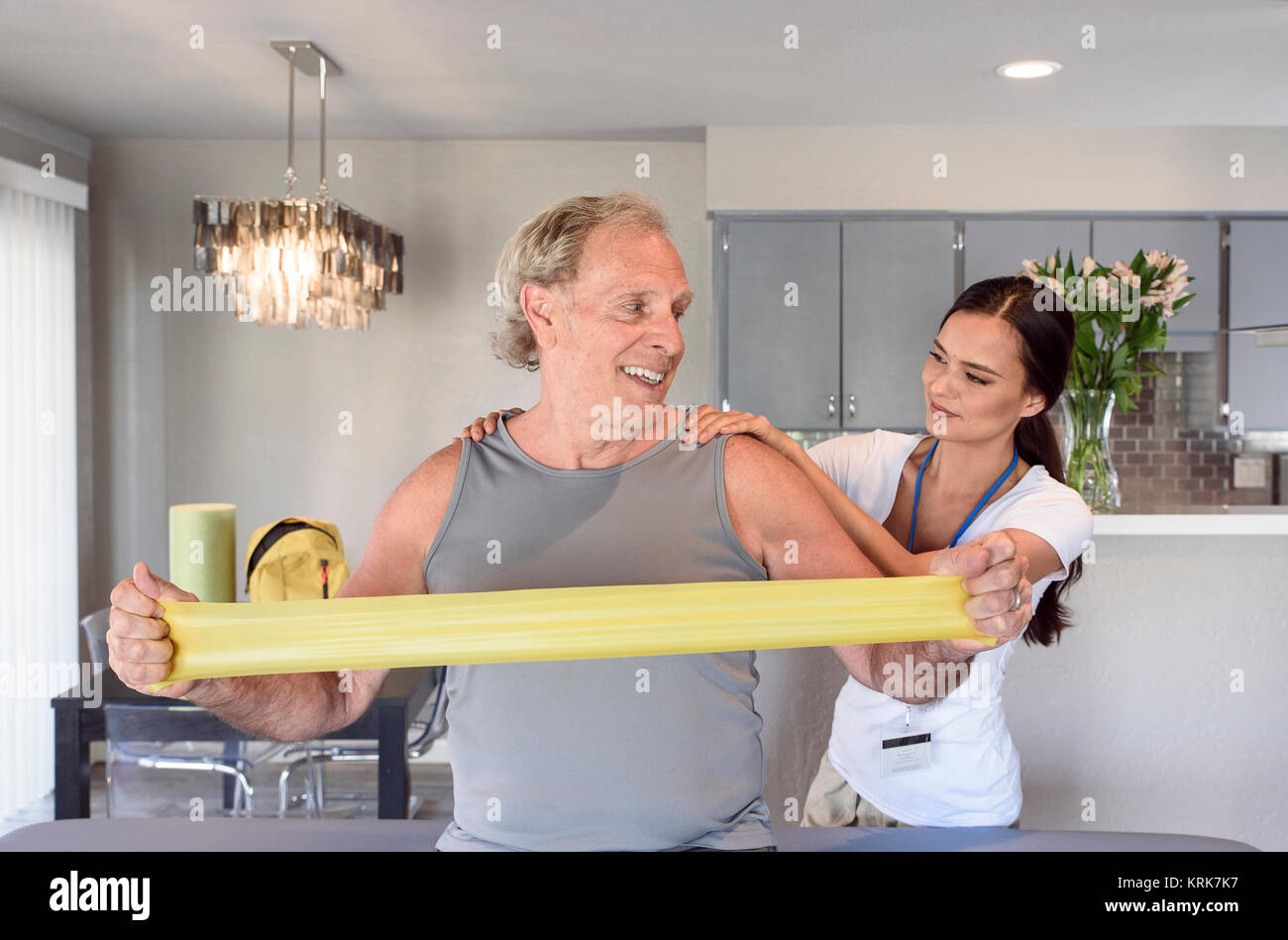 Physical therapist helping man using resistance band Stock Photo Alamy