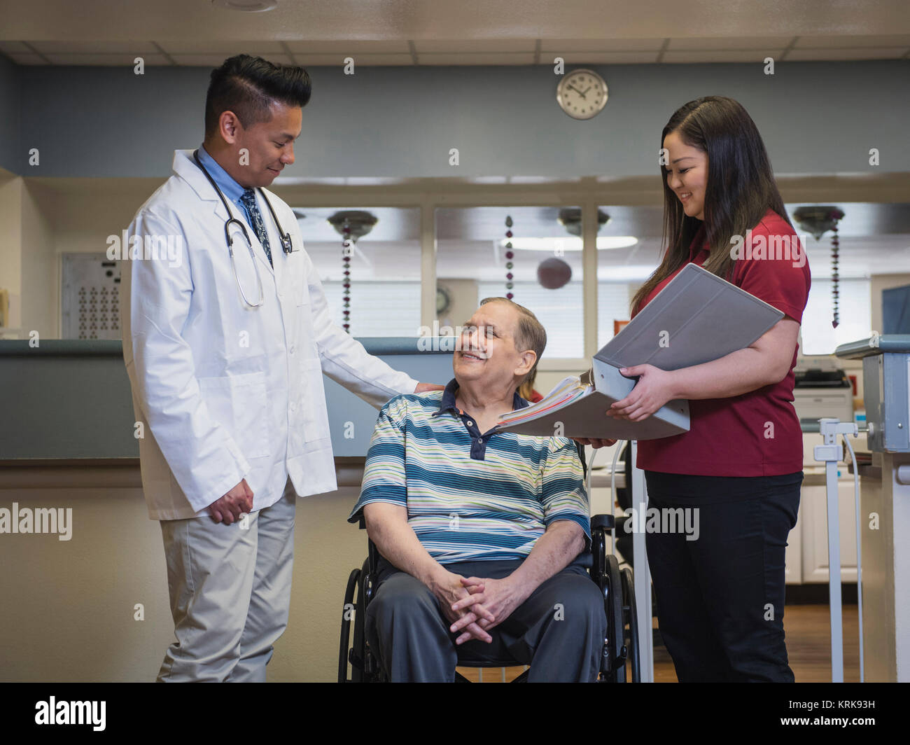 Doctor comforting patient in wheelchair Stock Photo