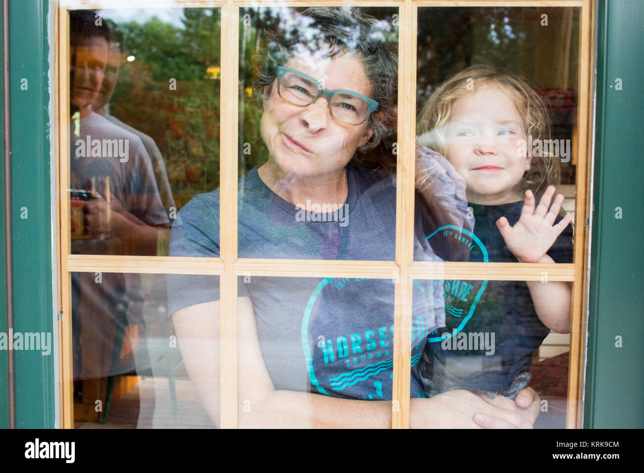 Caucasian mother and son making a face in door window Stock Photo