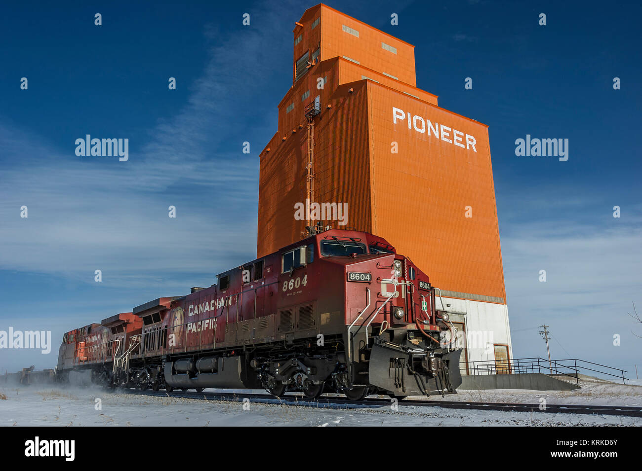 CP Rail intermodal freight southbound led by loco 8604 passes old Pioneer elevator at Olds Alberta Stock Photo