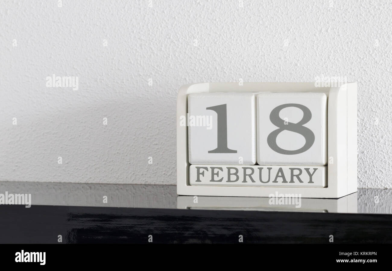 White block calendar present date 18 and month February on white wall ...