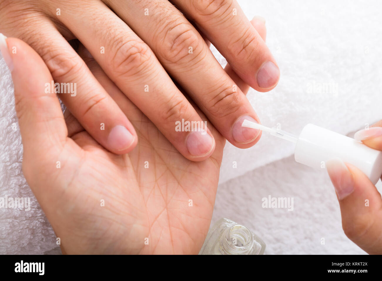 Manicurist Applying Moisturizing Oil On Person's Hand Stock Photo Alamy