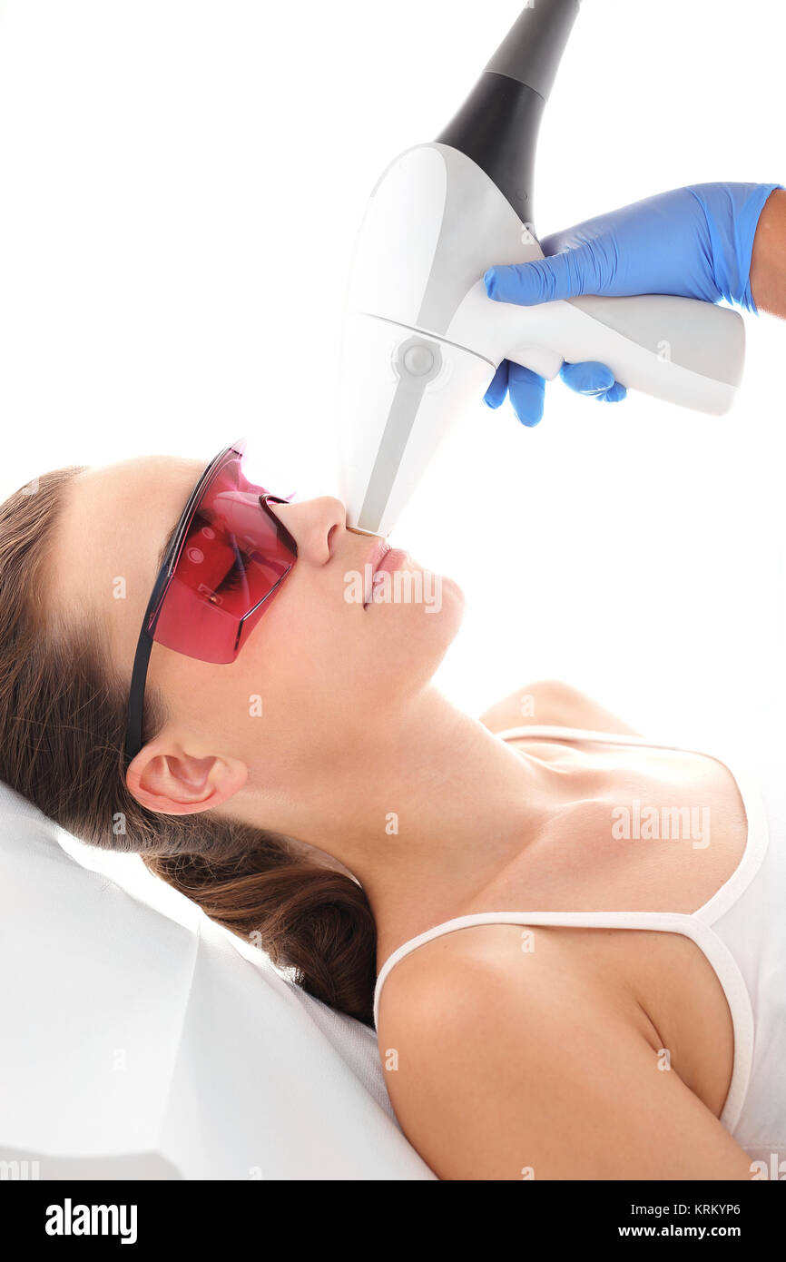 Klinika kosmetyczna, kobieta podczas zabiegu depilacji laserowej twarzy Stock Photo