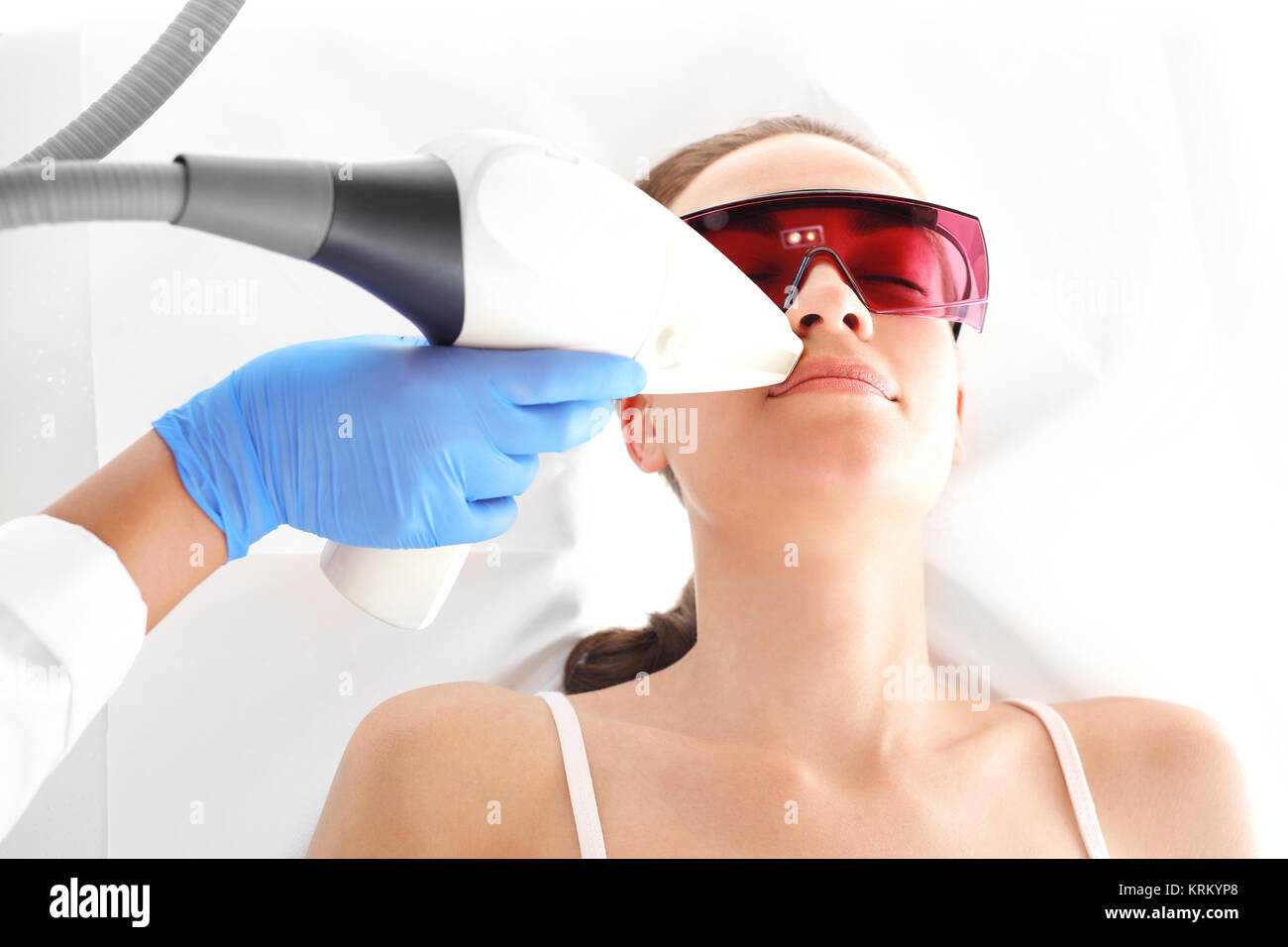 Klinika kosmetyczna, kobieta podczas zabiegu depilacji laserowej twarzy Stock Photo