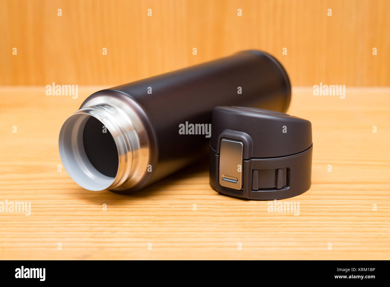 opened burgundy vacuum tumbler with safety lock on wooden table Stock