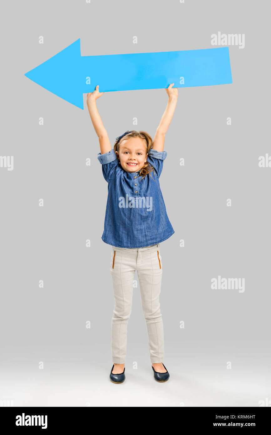 Girl holding a big blue arrow Stock Photo - Alamy