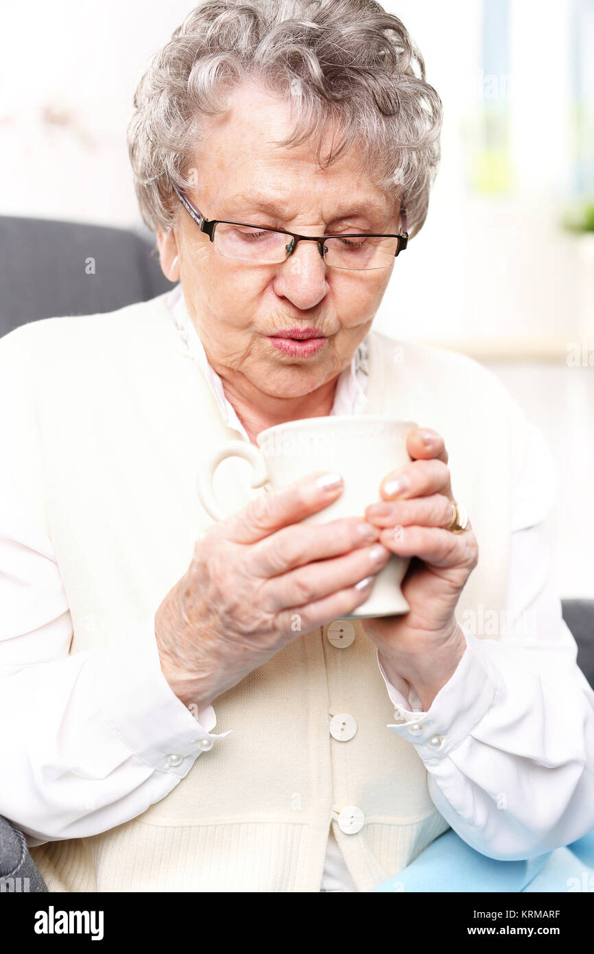 the old lady drinking a brew of herbs. grandma's first aid kit,infusion of herbs. Stock Photo