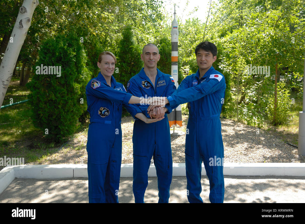 At the Cosmonaut Hotel in Baikonur, Kazakhstan, Expedition 48-49 crewmembers Kate Rubins of NASA (left), Anatoly Ivanishin of Roscosmos (center) and Takuya Onishi of the Japan Aerospace Exploration Agency (right) pose for pictures June 30 during traditional pre-launch activities. Rubins, Ivanishin and Onishi will launch July 7, Baikonur time, on the Soyuz MS-01 spacecraft for a planned four-month mission on the International Space Station.  NASA/Alexander Vysotsky Soyuz MS-01 crew in front of a Soyuz rocket statue Stock Photo
