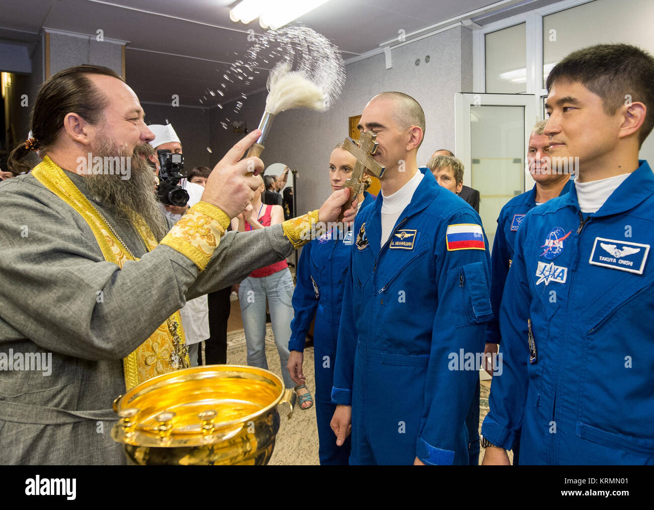 Anatoly Ivanishin of Roscosmos, left, and Takuya Onishi of the Japan Aerospace Exploration Agency (JAXA) receive a traditional blessing from a Russian Orthodox Priest along with NASA astronaut Kate Rubins prior to departing the Cosmonaut Hotel, Thursday, July 7, 2016 in Baikonur, Kazakhstan. Rubins, Ivanishin, and Onishi launched onboard their Soyuz MS-01 spacecraft later the same morning. The three will spend approximately four months on the orbital complex, returning to Earth in October. Photo Credit: (NASA/GCTC/Andrey Shelepin) Expedition 48 Blessing (NHQ201607070049) Stock Photo