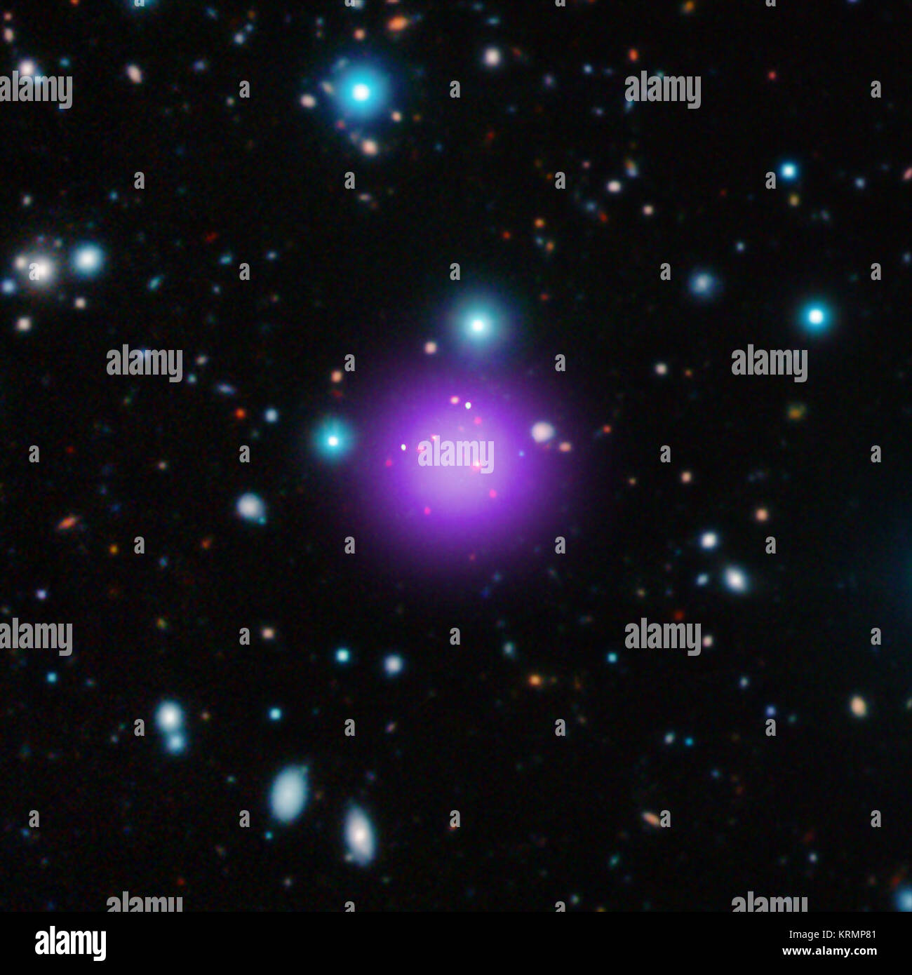 The galaxy cluster CL J1001+0220 is the most distant galaxy cluster ever discovered and may have been caught right after birth, a brief, but important stage of cluster evolution never seen before. This composite shows CL J1001+0220 in X-rays from Chandra (purple), infrared data from the UltraVISTA telescope (red, green, and blue), and radio waves from ALMA (green). The discovery of this object pushes back the formation time of galaxy clusters - the largest structures in the Universe held together by gravity - by about 700 million years. Composite X-Ray Radio and Infrared of galaxy cluster CL J Stock Photo