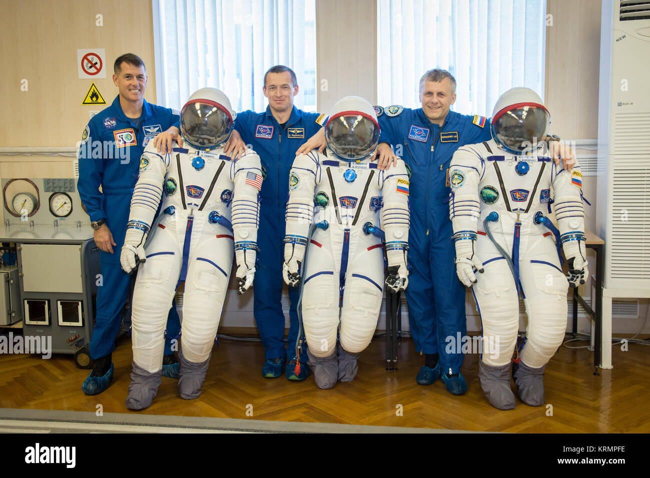 At the Integration Facility at the Baikonur Cosmodrome in Kazakhstan, Expedition 49 crewmembers Shane Kimbrough of NASA (left) and Sergey Ryzhikov (center) and Andrey Borisenko (right) of Roscosmos share a light-hearted moment Sept. 9 as they pose for pictures with their Sokol launch and entry suits during a pre-launch training fit check. Kimbrough, Ryzhikov and Borisenko will launch Sept. 24, Kazakh time on the Soyuz MS-02 vehicle for a five-month mission on the International Space Station.  NASA/Victor Zelentsov Soyuz MS-02 crew members with their space suits Stock Photo