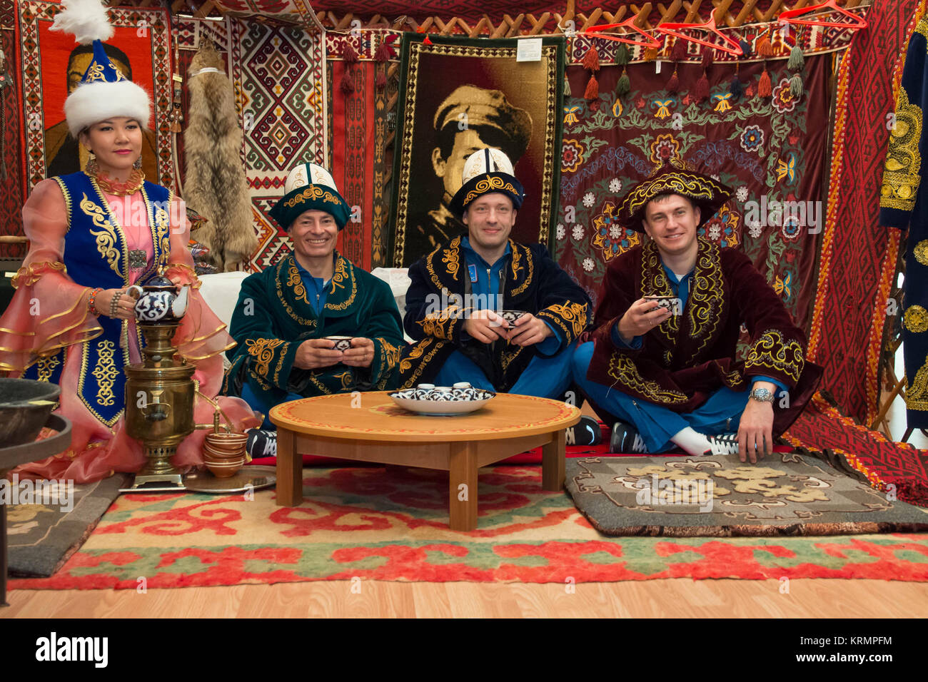Wearing native garb, Expedition 49 backup crewmembers Mark Vande Hei of NASA and Alexander Misurkin and Nikolai Tikhonov of Roscosmos enjoy a cup a tea in a traditional Kazakh setting at a local museum Sept. 10 while on a tour of the city of Baikonur, Kazakhstan. They are serving as backups to Shane Kimbrough of NASA and Sergey Ryzhikov and Andrey Borisenko of Roscosmos, who will launch on Sept. 24, Kazakh time from the Baikonur Cosmodrome in Kazakhstan on the Soyuz MS-02 vehicle for a five-month mission on the International Space Station.  NASA/Victor Zelentsov Soyuz MS-02 backup crew during  Stock Photo