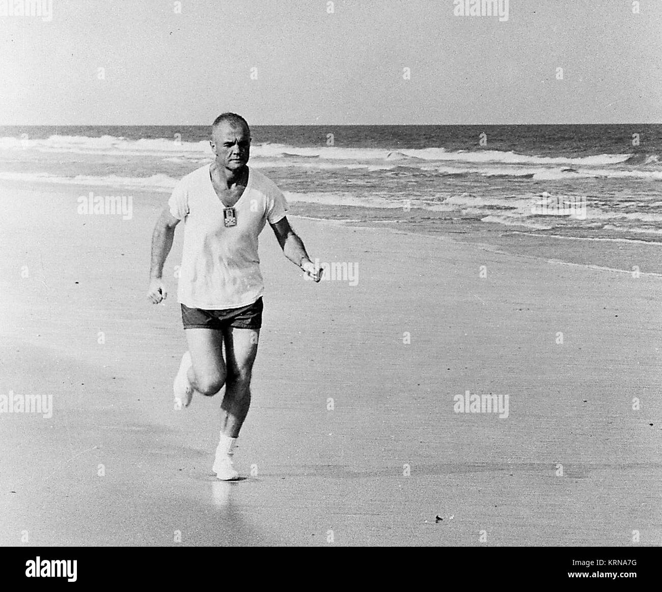 1962 -- Running along the beach at Cape Canaveral, Florida, astronaut John H. Glenn Jr., pilot of the Mercury-Atlas 6 mission, participates in a strict physical training program, as he exemplifies by frequent running.  Photo credit: NASA KSC-JohnGlenn-0005 (31144829360) Stock Photo