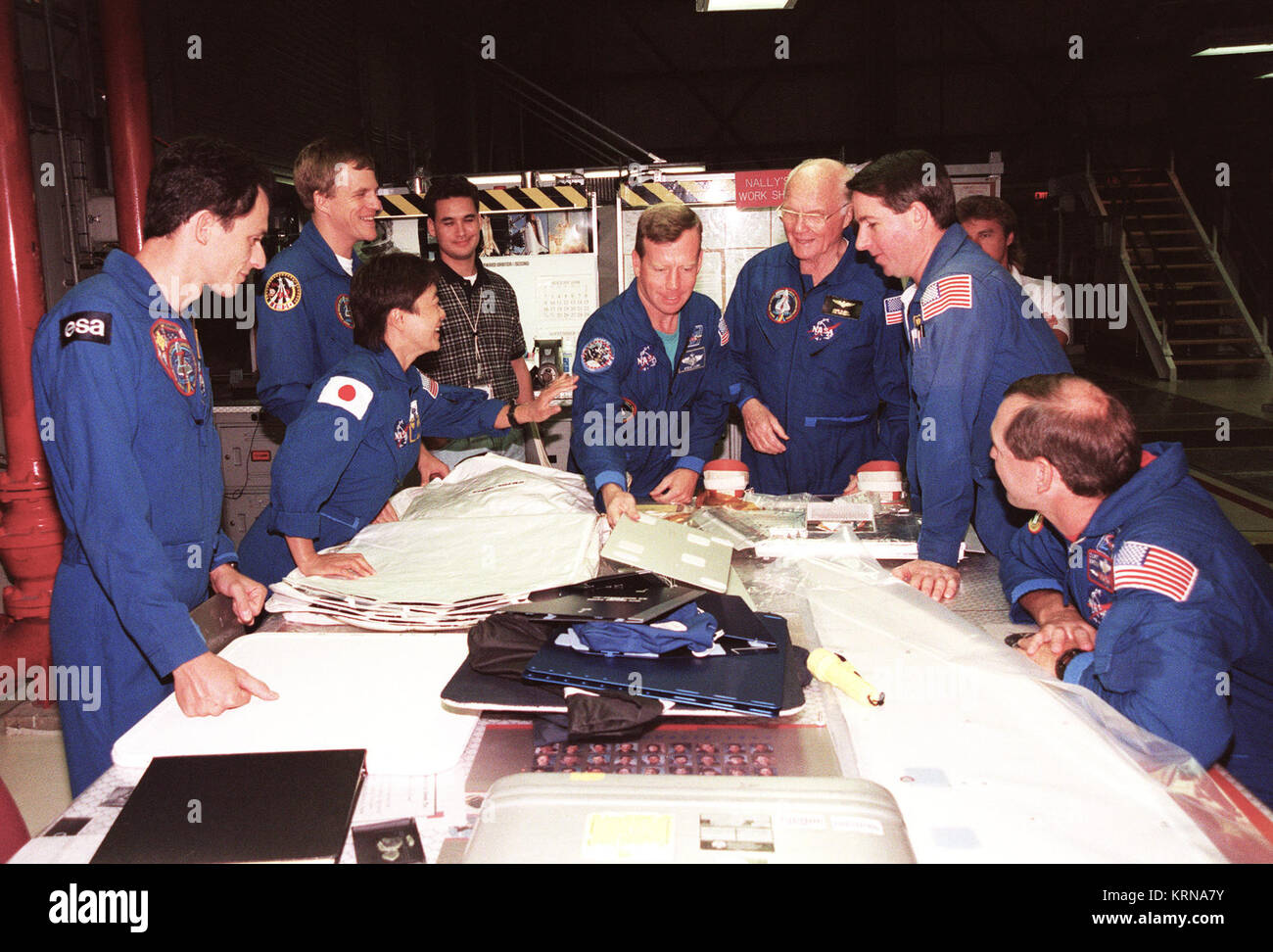 Sept. 3, 1998 -- Around a table in Bay 2 Orbiter Processing Facility at NASA's Kennedy Space Center in Florida, STS-95 crew members look over equipment during the Crew Equipment Interface Test (CEIT) for their mission. From left, they are Mission Specialist Pedro Duque, of the European Space Agency; Payload Specialist Chiaki Mukai, of the National Space Development Agency of Japan (NASDA); Mission Specialist Scott E. Parazynski, M.D.; Pilot Steven W. Lindsey; Payload Specialist John H. Glenn Jr., senator form Ohio; Mission Specialist Stephen K. Robinson; and Mission Commander Curtis L. Brown J Stock Photo