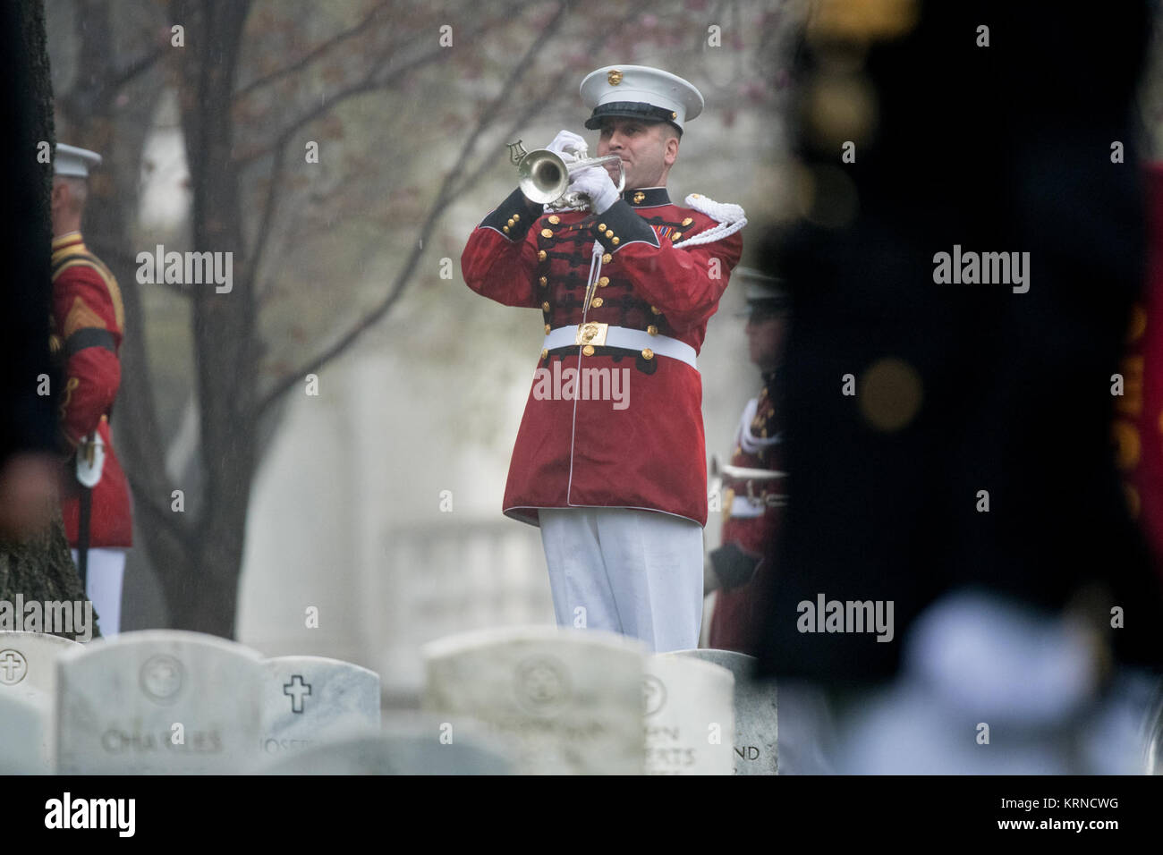 'Taps' is played during the funeral service for former astronaut and U.S. Senator John Glenn, who was buried with full military honors, at Arlington National Cemetery in Virginia on Thursday, April 6, 2017, the day on which he and his wife Annie were married in 1943. Glenn was the first American to orbit Earth on Feb. 20, 1962, in a five-hour flight aboard the Friendship 7 spacecraft. In 1998, he broke another record by returning to space at the age of 77 on the Space Shuttle Discovery. Photo Credit: (NASA/Aubrey Gemignani) John Glenn Interment (NHQ201704060012) Stock Photo