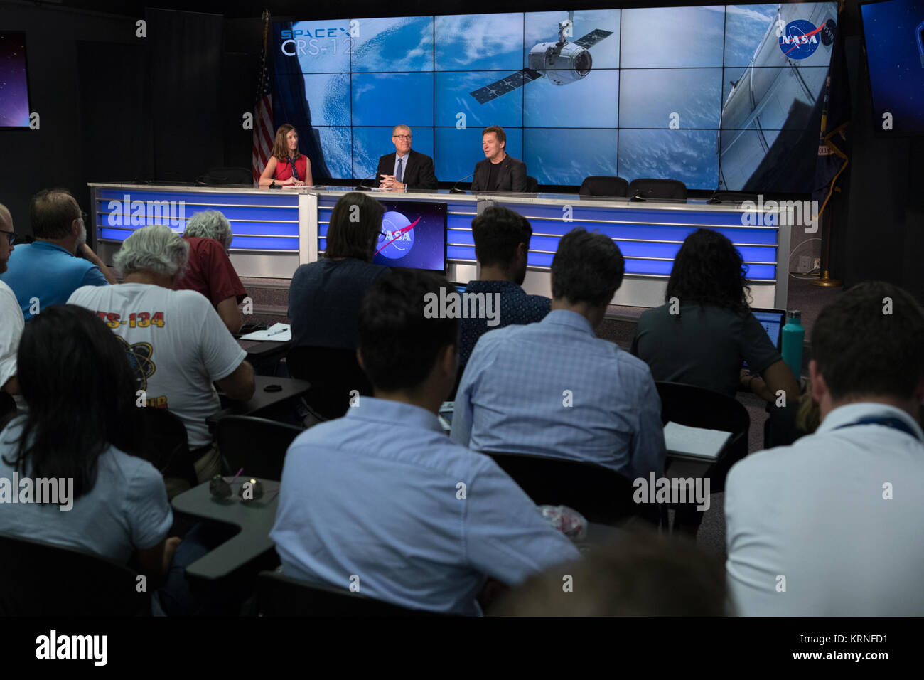 In the Press Site auditorium of NASA's Kennedy Space Center in Florida, NASA and industry leaders speak to media at a post-launch news conference following the liftoff of SpaceX CRS-12, a commercial resupply services mission to the International Space Station. From left are: Stephanie Martin of NASA Communications, Dan Hartman, NASA deputy manager of the International Space Station Program, and Hans Koenigsmann, SpaceX  vice president of Flight and Build Reliability. SpaceX CRS-12 lifted off atop a Falcon 9 rocket from Kennedy's Launch Complex 39A at 12:31 p.m. EDT. KSC-20170814-PH KLS03 0058  Stock Photo