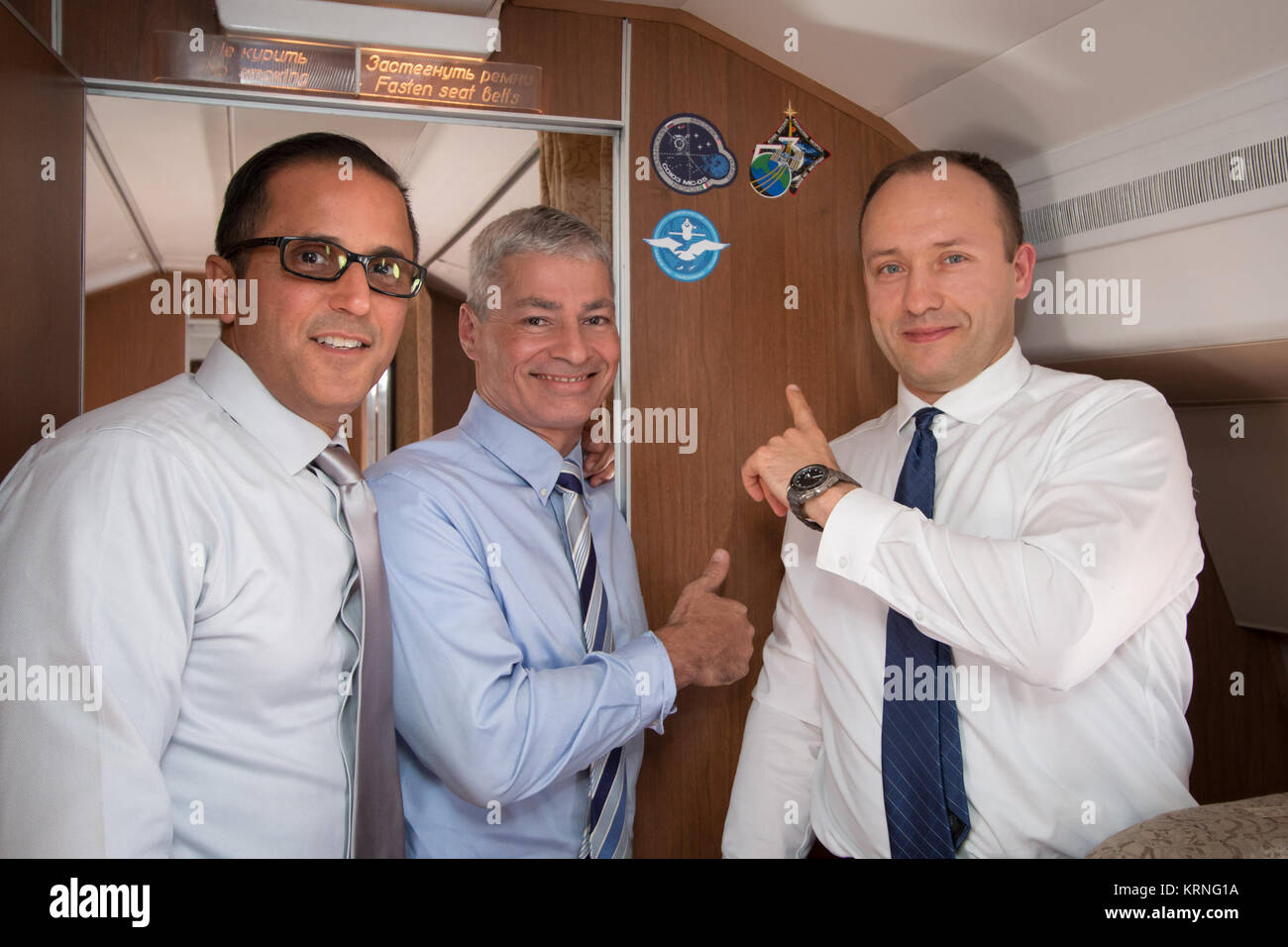 Aboard the Gagarin Cosmonaut Training Center Aircraft en route from their training base to their launch site at the Baikonur Cosmodrome in Kazakhstan for final pre-launch training, Expedition 53-54 crewmembers Joe Acaba (left) and Mark Vande Hei (center) of NASA and Alexander Misurkin of Roscosmos (right) point to the stickers bearing their mission insignias Sept. 6. They will launch Sept. 13 on the Soyuz MS-06 spacecraft from the Baikonur Cosmodrome for a five and a half month mission on the International Space Station.  NASA/Victor Zelentsov Soyuz MS-06 crew aboard a Russian Federal Space Ag Stock Photo