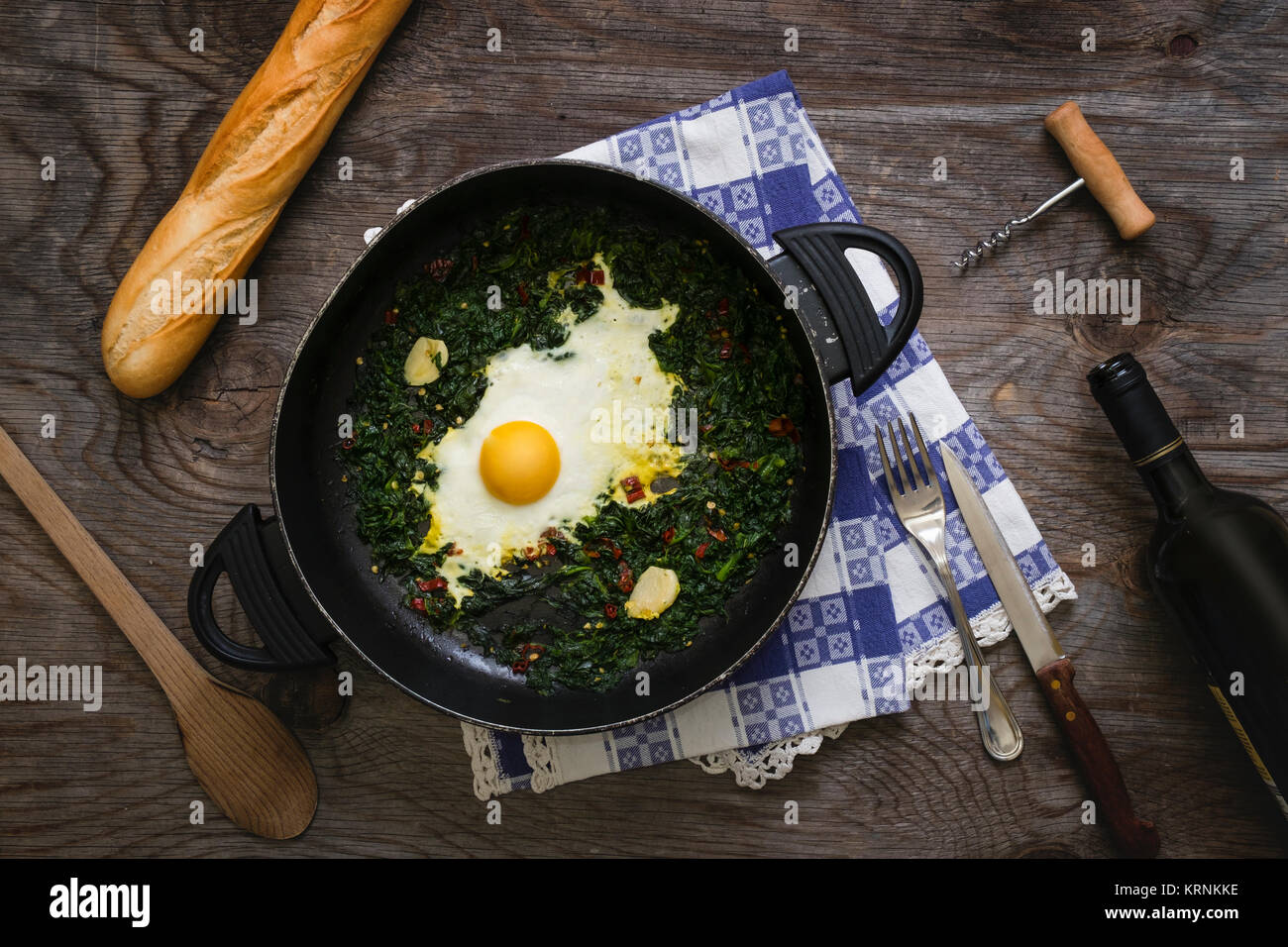 Fried eggs and spinach in a pan Stock Photo - Alamy