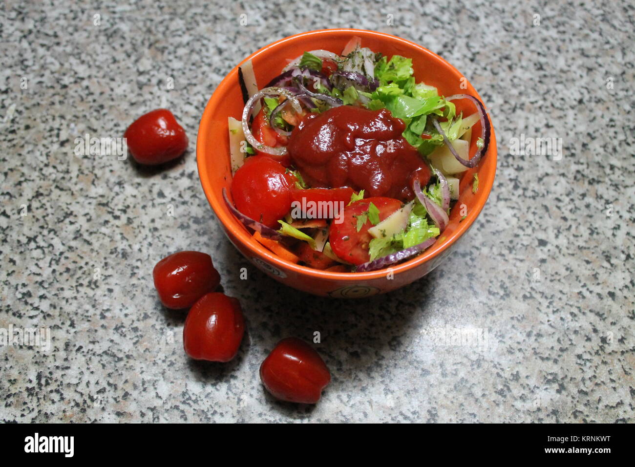 appetizing vegetarian salad   from ripe cherry tomato in clay orange bowl Stock Photo