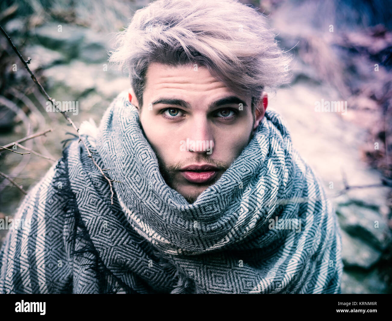 Headshot of young man in hoodie posing outdoor in winter setting with