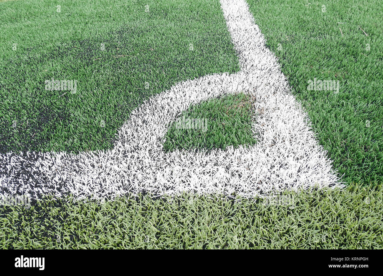 Close up on football field with artificial grass and white stripes