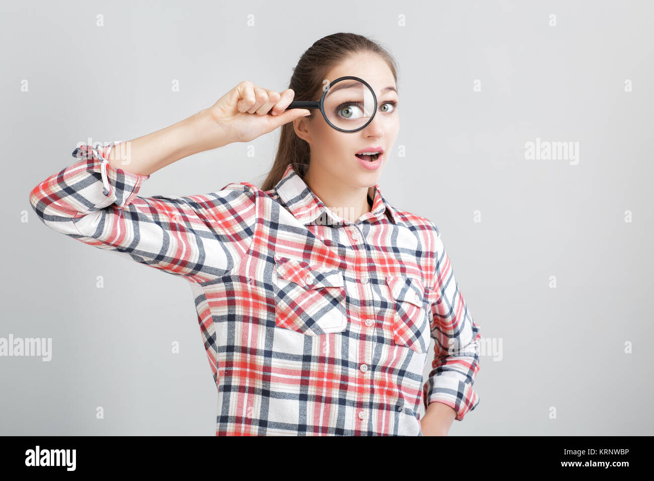 woman looks through a magnifying glass Stock Photo - Alamy