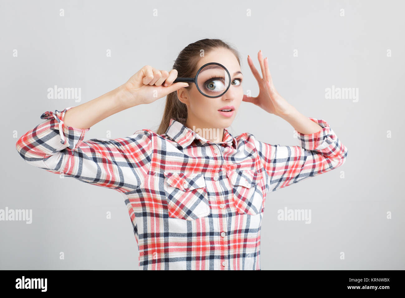 woman looks through a magnifying glass Stock Photo - Alamy