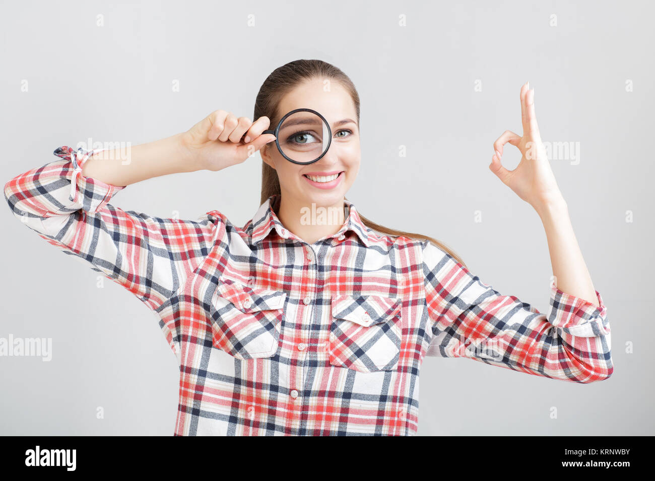 woman looks through a magnifying glass Stock Photo - Alamy