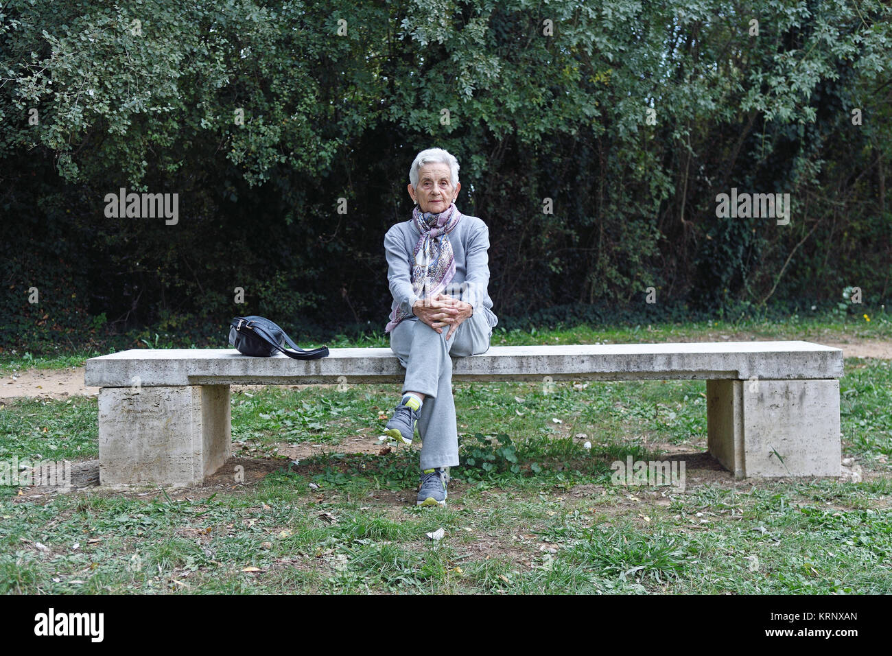 senior woman sitting alone on a bench in a park Stock Photo - Alamy