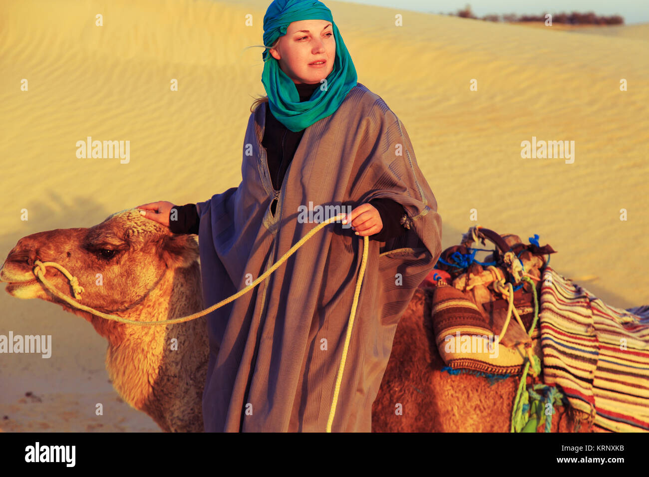 Woman in Bedouin dress with a camel in the Sahara desert, Tunisia, Africa  Stock Photo - Alamy