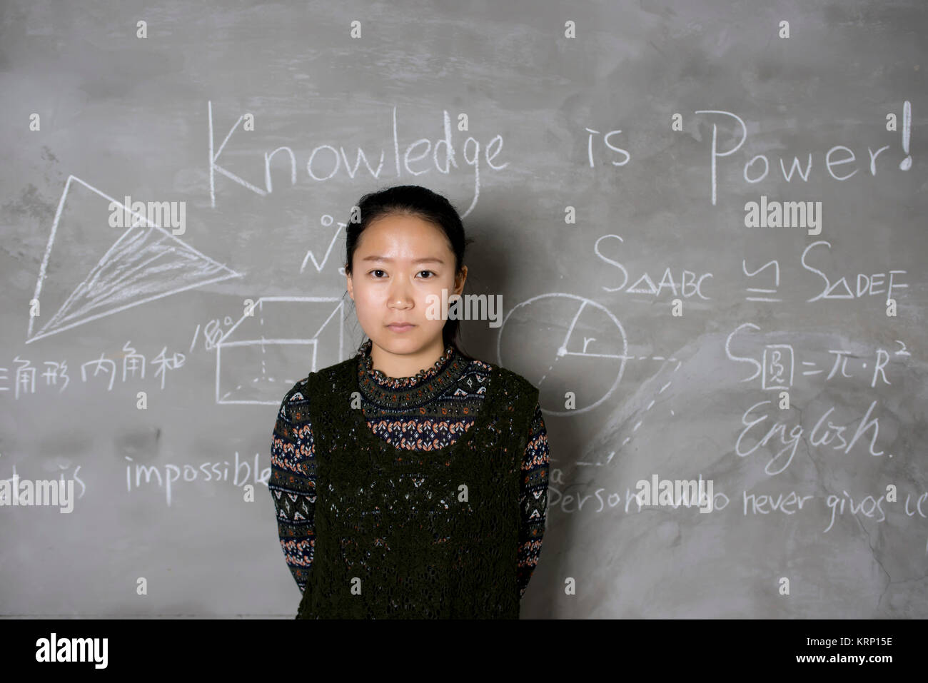 Confident female college students stand in front of the blackboard. Stock Photo