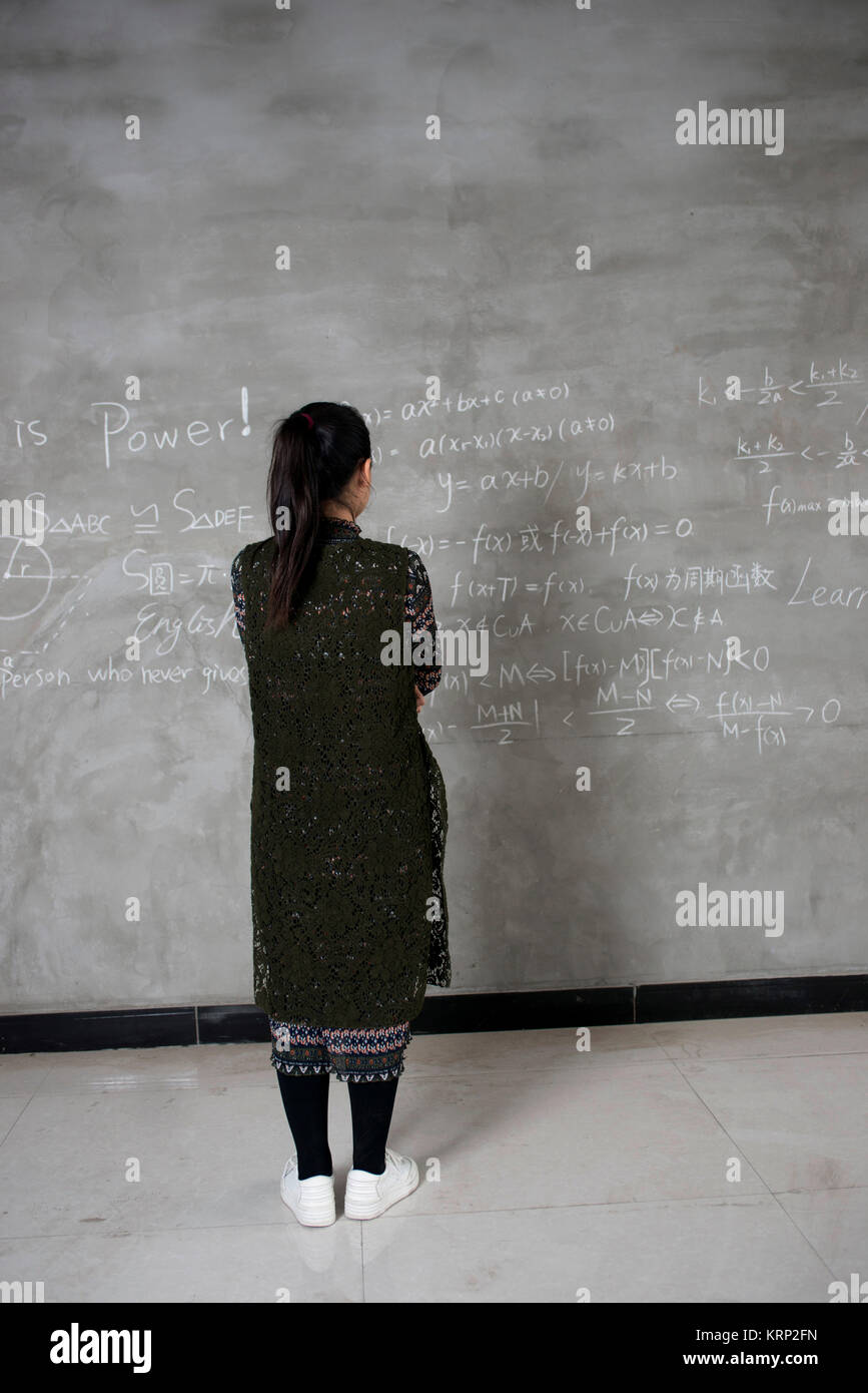 Asians female college student writing on the chalkboard blackboard during a chemistry class Stock Photo