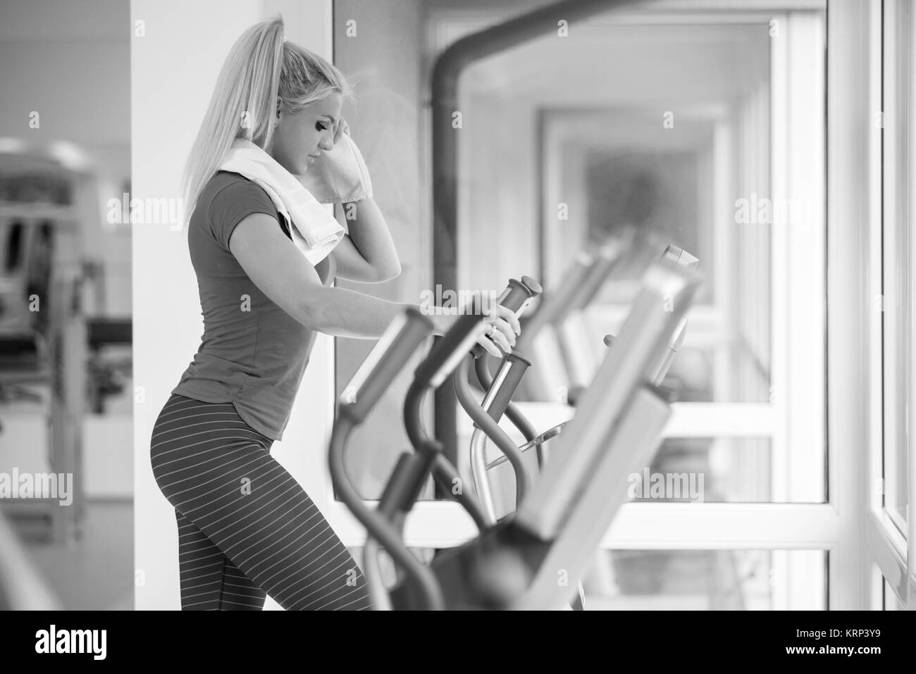sport, fitness, lifestyle, technology and people concept - woman with or player and earphones exercising on treadmill in gym Stock Photo