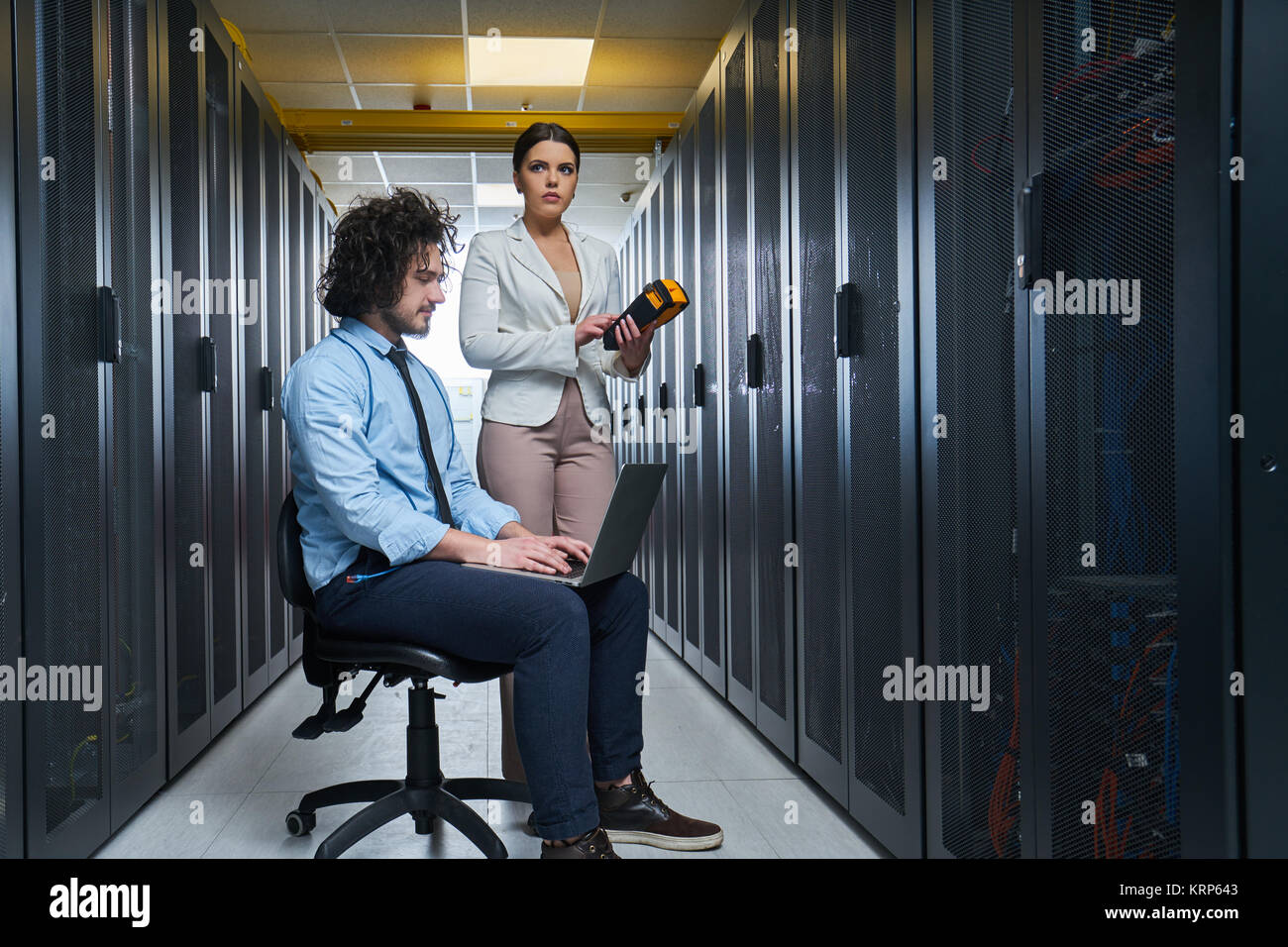two young technicians working at a data center on server maintenance ...