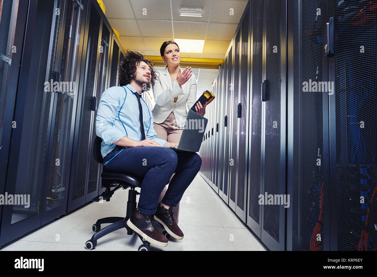 two young technicians working at a data center on server maintenance ...